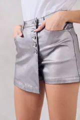 Skort plateada metalizada con cierre de botones frontal y corte asimétrico.