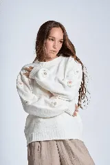 Sweater color crema de hilado frizado con cuello redondo y apliques de flores color beige en las mangas.