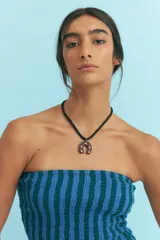 Collar con cordón negro y dije de herradura marrón con apliques dorados.