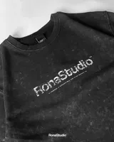 Remera negra con efecto gastado y logo estampado en el frente.