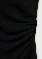 Vestido midi negro de corte recto, con cuello drapeado y diseño sin mangas. Presenta un detalle de drapeado lateral en la cintura y cierre de cremallera oculto en el lateral.