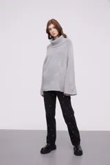 Sweater de punto con cuello alto tipo polera, de calce holgado y mangas largas con diseño acampanado.