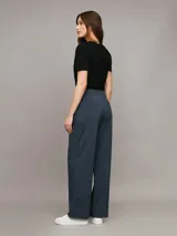 Pantalón de vestir azul petróleo, de corte sastre y pierna ancha. Presenta bolsillos laterales, cierre con clip y cremallera. Confeccionado en poliéster reciclado, ecovero viscosa y elastano.