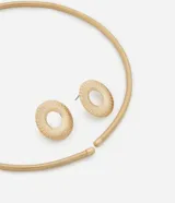 Conjunto de bisutería en color dorado compuesto por una gargantilla rígida de diseño circular y un par de aros tipo botón con textura estriada y centro calado.