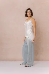 Musculosa de satén color crema con breteles finos regulables, escote en V y detalles de encaje en el escote, en diagonal sobre el delantero y en el ruedo.