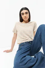 Remera corta a rayas horizontales color beige y blanco, de mangas cortas y cuello redondo.