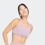 Top deportivo de soporte medio, color lila claro, con escote redondo y tirantes anchos. Presenta un bolsillo trasero para teléfono y banda elástica de apoyo inferior.