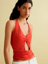 Top de tul color rojo, con diseño entallado, cuello halter con cierre de lazo y detalle de abertura frontal con fruncidos.
