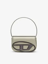 Bolso Diesel modelo 1DR, color gris metalizado, con forma de media luna y asa corta para llevar al hombro. Presenta el logo ovalado de la marca en el frente.