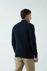 Sweater gris de punto con cuello alto y medio cierre con cremallera.
