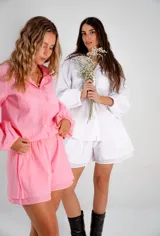 Conjunto de dos piezas compuesto por una camisa de corte relajado con mangas largas abullonadas y puños elásticos, y un short de tiro medio con cintura elástica y diseño de doble ruedo. Confeccionado en lino liviano.