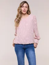 Blusa blanca de organza con textura devoré floral, silueta semiholgada y forro interno. Tiene escote bote, mangas largas abullonadas con transparencias, puños anchos con botones y ruedo elastizado.