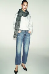 Jeans de tiro medio con cinco bolsillos, pernera recta y corte cropped. Cierre frontal con cremallera y botón.