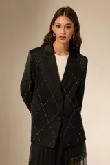 Blazer negro de poliéster con cuello solapa, cierre frontal con botones y bolsillos laterales. Presenta un diseño de rombos formados por pequeñas incrustaciones de strass en toda la prenda.