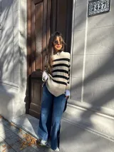 Sweater de tejido de punto con diseño de rayas horizontales en color beige y negro, de corte relajado, cuello redondo y mangas largas.