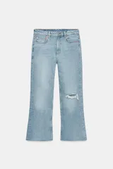 Jeans de tiro medio y corte bootcut cropped de Zara Woman Collection. Confeccionados en denim de efecto lavado en color celeste, presentan diseño de cinco bolsillos, trabillas para cinto, detalle de rotura en la rodilla izquierda y bajo evasé sin costuras. Cierre frontal con cremallera y botón metálico.