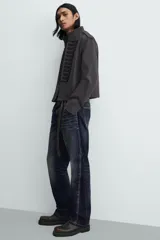 Chaqueta cropped de algodón con cuello mao y manga larga. Presenta un diseño de inspiración militar con alamares decorativos en contraste en el frente, trabillas en los hombros y cierre frontal con ganchos metálicos.