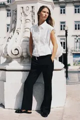 Camisa blanca de popelín con cuello solapa, manga sisa y detalle de guipur floral en el frente. Incluye un cinturón fino del mismo tejido que se ata en la cintura.