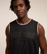 Musculosa deportiva de baloncesto negra con cuello y sisas en blanco. Estampado frontal con la leyenda "New York" y el número 7.
