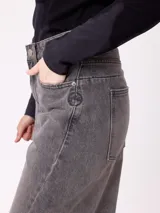 Jean de corte wide leg con diseño de pata ancha y costuras laterales visibles. Presenta un lavado azul clásico con efecto desgastado y cierre frontal con botón y cremallera.