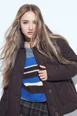 Campera acolchada de color negro con diseño capitoneado, cierre frontal con botones y cuello clásico.
