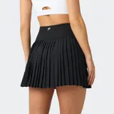 Minifalda plisada de tiro alto con shorts incorporados, confeccionada en tejido técnico transpirable. Presenta un diseño deportivo con cintura elástica ancha y bolsillos ocultos.