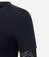 Blusa tipo baby look color negro, con cuerpo de algodón y mangas largas integradas de encaje con diseño floral. Presenta un diseño de superposición que simula una manga corta sobre la manga larga de encaje.
