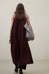 Vestido largo blanco de lino ligero, sin mangas, con cuello redondo y silueta fluida.