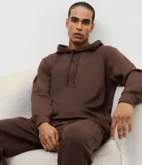 Buzo de pijama con capucha ajustable y cordones, de manga larga con puños y ruedo elásticos. Confeccionado en tejido modal suave y ligero.