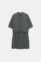 Vestido corto de color gris, con cuello subido, manga corta y diseño de cuerpo holgado con bajo tipo globo. Presenta cierre en la espalda con botones y cremallera oculta.