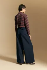 Pantalón de vestir negro de corte ancho y tiro alto, con silueta fluida y diseño minimalista.