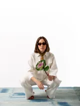 Pantalón de lino blanco de corte holgado, con cintura elástica ajustable con cordón, dos bolsillos laterales y un bolsillo trasero.