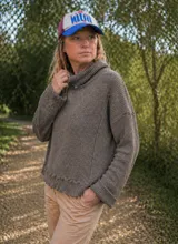 Polerón de punto inglés color marrón, con cuello alto tipo polera, mangas largas y diseño holgado con terminación acanalada en el ruedo.