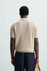 Polo de manga corta, corte regular fit, color verde oliva. Tejido de punto con textura acanalada vertical y cuello solapa con dos botones.