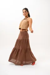 Pollera larga marrón de tiro medio, confeccionada en lino con diseño en niveles y vuelo.