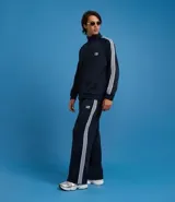 Pantalón deportivo de corte recto y holgado, color negro con rayas blancas laterales. Cuenta con cintura elástica con cordón ajustable, bolsillos laterales y detalle de costura vertical frontal.