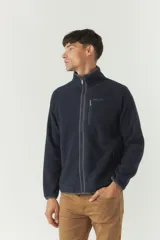 Campera polar gris de poliéster con cuello elevado, cierre frontal, bolsillos laterales con cierre y logo estampado en el pecho.