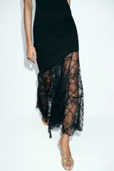 Vestido midi de cuello redondo y sin mangas, confeccionado en tejido liso con un panel inferior asimétrico de encaje negro.