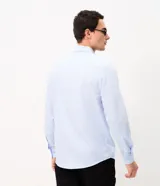 Camisa de corte regular para hombre, en color celeste con finas rayas verticales blancas. Cuenta con cuello camisero tradicional, mangas largas con puños abotonados y cierre frontal con botones.