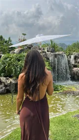 Vestido largo de microtul color marrón, con escote buche y cuello halter regulable. Presenta un diseño ajustado al cuerpo con forro interno corto.