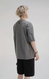 Remera de corte holgado y diseño minimalista, con cuello redondo y mangas cortas de hombros caídos. Confeccionada en algodón premium, presenta un largo a la altura de la cadera.