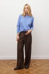 Pantalon de corte recto y pierna ancha, confeccionado en tejido tipo denim oscuro. Presenta tiro alto, cintura con cierre frontal y bolsillos laterales funcionales.