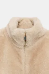 Chaleco de efecto pelo con cuello subido, diseño sin mangas y cierre frontal con cremallera metálica.