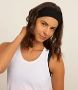 Musculosa deportiva de corte nadador, color amarillo claro, confeccionada en microfibra con textura perforada. Presenta escote en U y diseño holgado con pliegue en la espalda.
