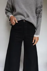 Pantalón de pierna ancha con tiro medio, confeccionado en brin de algodón con spandex. Presenta costuras a contratono y cierre frontal con botón.