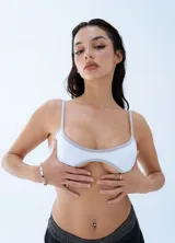 Microtop deportivo de color blanco con ribetes en color gris claro, de corte bajo y tirantes finos.