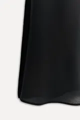 Top negro de seda con escote en pico, tirantes finos ajustables con lazadas, bajo recto con aberturas laterales y cierre en la espalda con cremallera oculta.