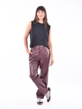 Pantalon de cuero sintetico color azul oscuro, de corte recto y tiro alto, con cintura con trabillas y cinturon incorporado con hebilla metalica dorada. Presenta bolsillos delanteros y costuras verticales decorativas.