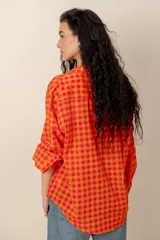 Camisa de manga larga con estampado tropical, fondo a rayas celestes y blancas, cuello camisero y cierre frontal de botones.