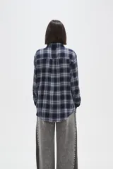 Camisa de algodón con estampado de cuadros en tonos marrones y blancos, de corte holgado, manga larga y cierre frontal con botones.